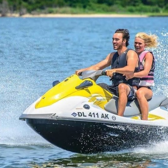 a person riding on the back of a boat in a body of water