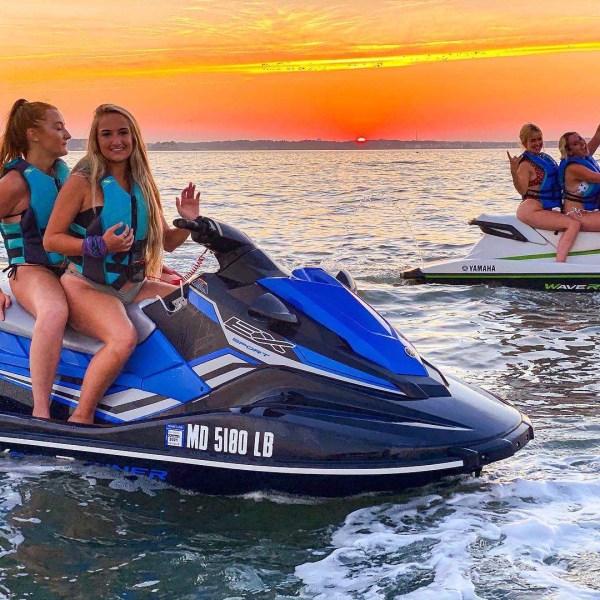 a group of people riding on the back of a boat in the water