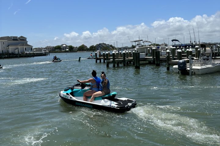 a person flying a kite in a boat on a body of water