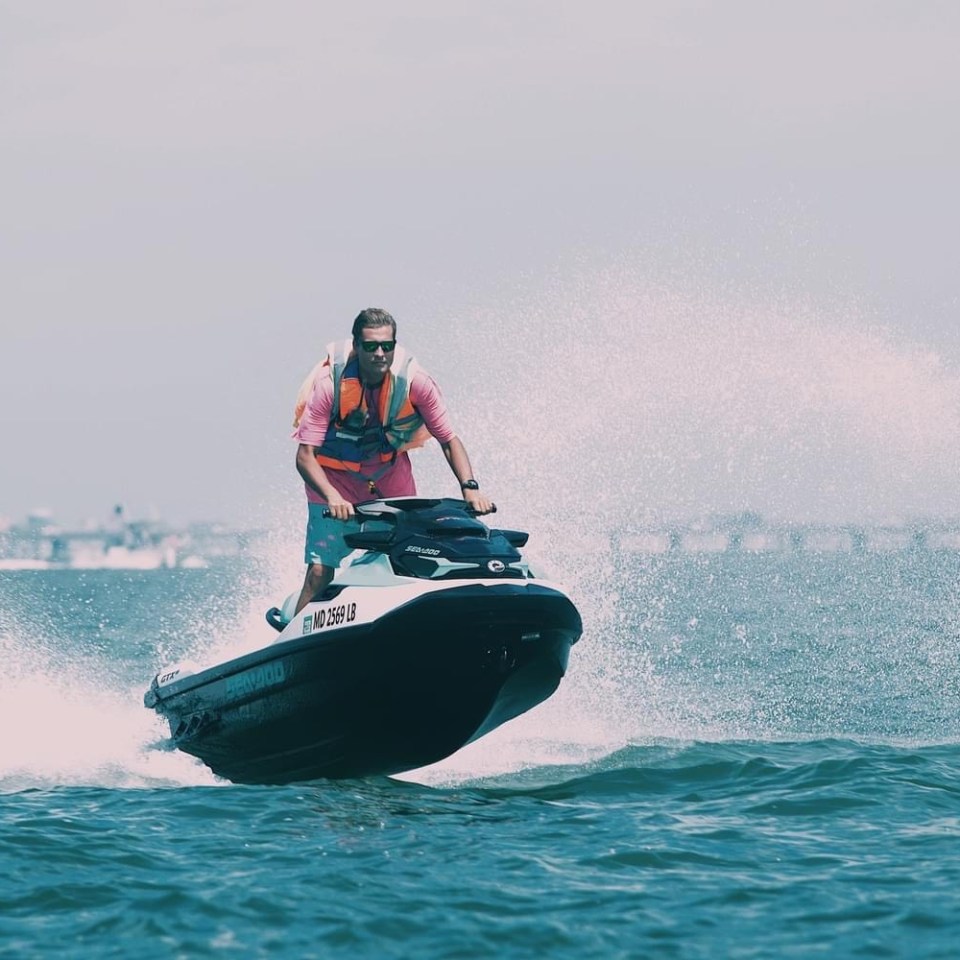 a man riding on the back of a boat in the water